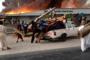 مواطنين مع تجار السوق الشعبي يحاولون إنقاذ ما يمكن إنقاذه