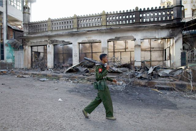 جندي يمر أمام مسجد أحرق إثر أعمال عنف جديدة     - REUTERS