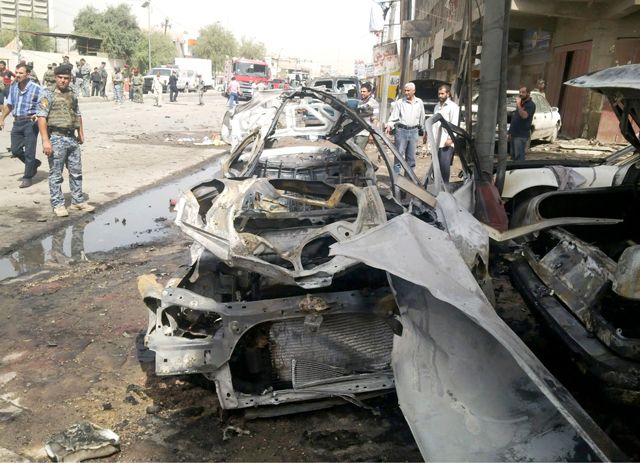 أفراد من قوات الأمن العراقية تتفقد موقع هجوم بقنبلة في بغداد - REUTERS