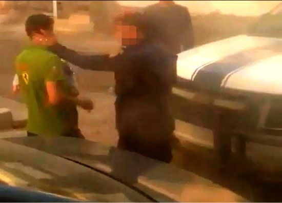 مشهد من فيديو انتشر على الإنترنت لرجل أمن يصفع مواطناً كان يحمل ابنه
