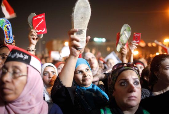 محتجون يرفعون أحذيتهم وهم يرددون شعارات مناهضة للإخوان ومرسي  في ميدان التحرير - reuters