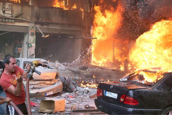 أحد عناصر قوات الطوارئ يحاول إخماد حرائق شبت إثر انفجار السيارة المفخخة في الضاحية الجنوبية - afp