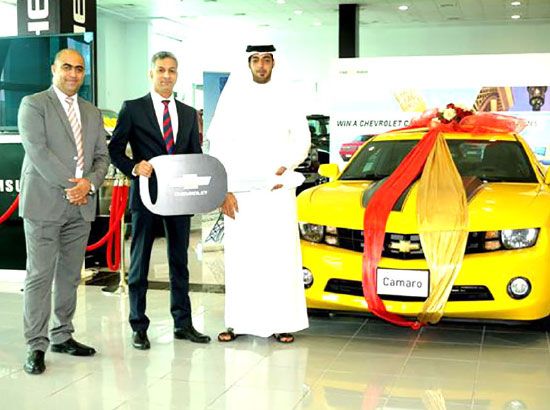 (من اليمين): الفائز جاسم سامي الأحمد، يتسلم جائزته من نادر إبراهيم بحضور غسان المحل   - تصوير عقيل الفردان