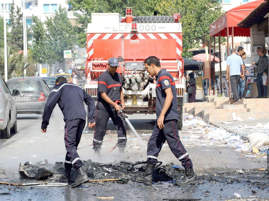 رجال الإطفاء التونسي يخمدون النار في ما تبقى من وثائق وأثاث خارج مكتب النهضة  الذي أحرق  في الكاف - afp