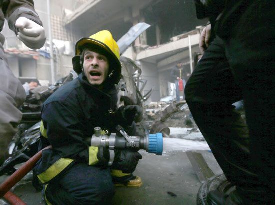 إطفائي يوجه خرطوم المياه نحو حريق شب بعد الانفجار  - reuters