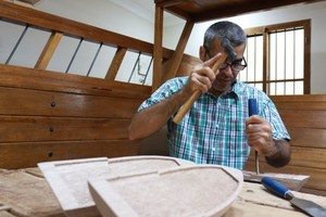 شاهد صور لرجل بحريني يعمل في( صناعة السفن) في مركز الحرفين في الجسرة  