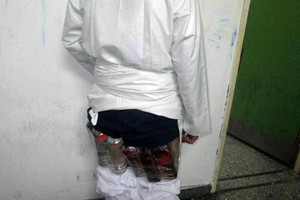 شاهد الصور... محاولة تهريب خمور أسفل ثوب مسافر في جسر الملك فهد