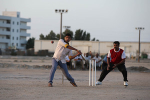 جالية من الهنود يلعبون الكريكيت في احد الساحات في سترة