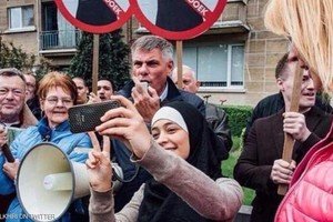 مسلمة محجبة تخترق مظاهرة ضد الحجاب وتلتقط سيلفي مع المشاركين!