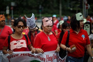 بالصور... تظاهرة لعاملات اجنبيات في هونغ كونغ ضد الزامهن بتنظيف الزجاج الخارجي في المباني العالية