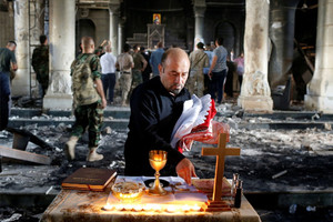 مسيحيون عراقيون يعودون للصلاة في كنيستهم 'المحترقة' قرب الموصل