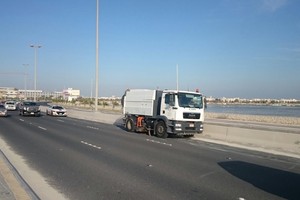 بالصور... بلدية المحرق وشركة النظافة تزيلان أكوام رمال جمعتها الرياح بجسر الشيخ عيسى بن سلمان 